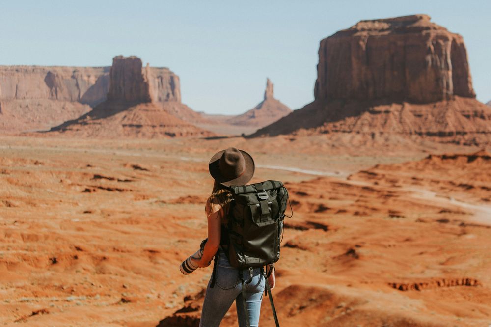 A woman in hiking in a valley, representing the decision between solo travel or group travel