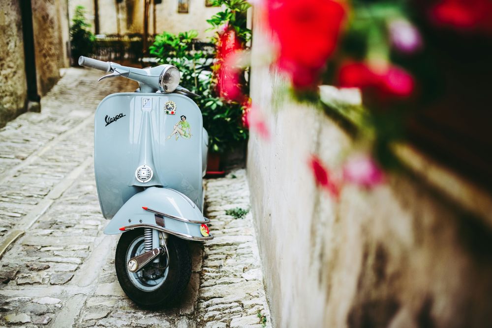 A vespa in an Italian street part of the 20 Great Italy Travel Tips