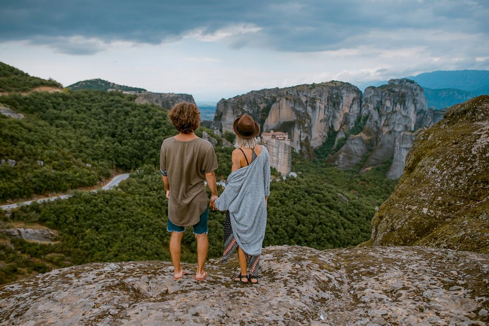 Two travellers in the mountains in The Best Money Saving Travel Hacks to Have in 2025