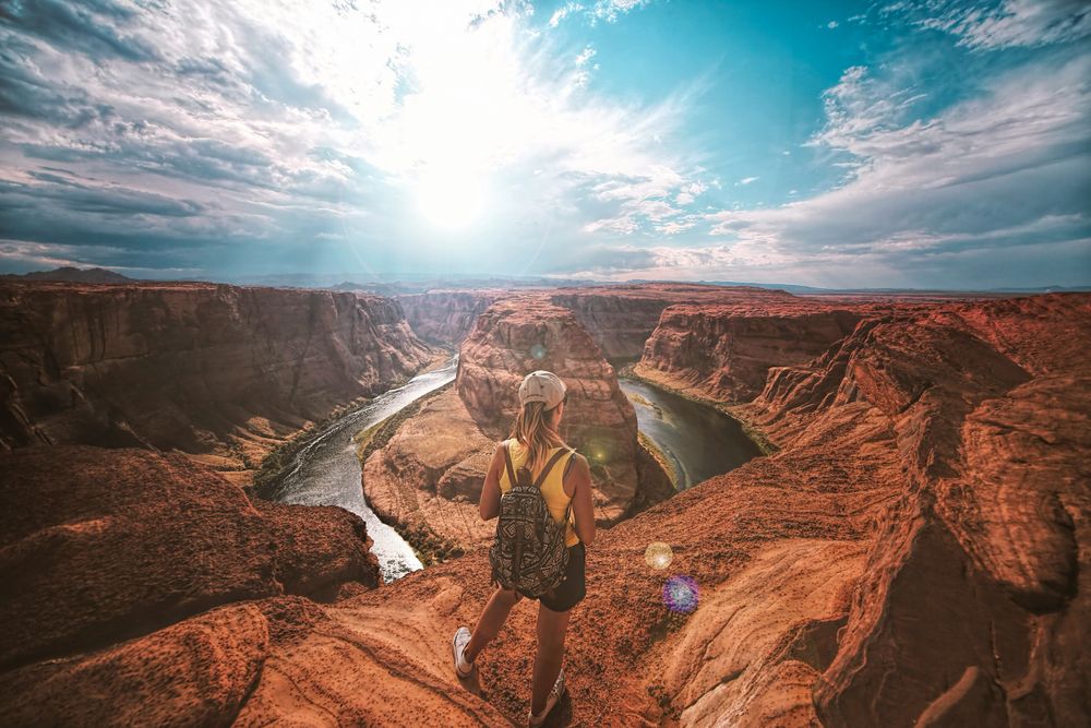 woman standing on the edge of a canyon, representing AI travel