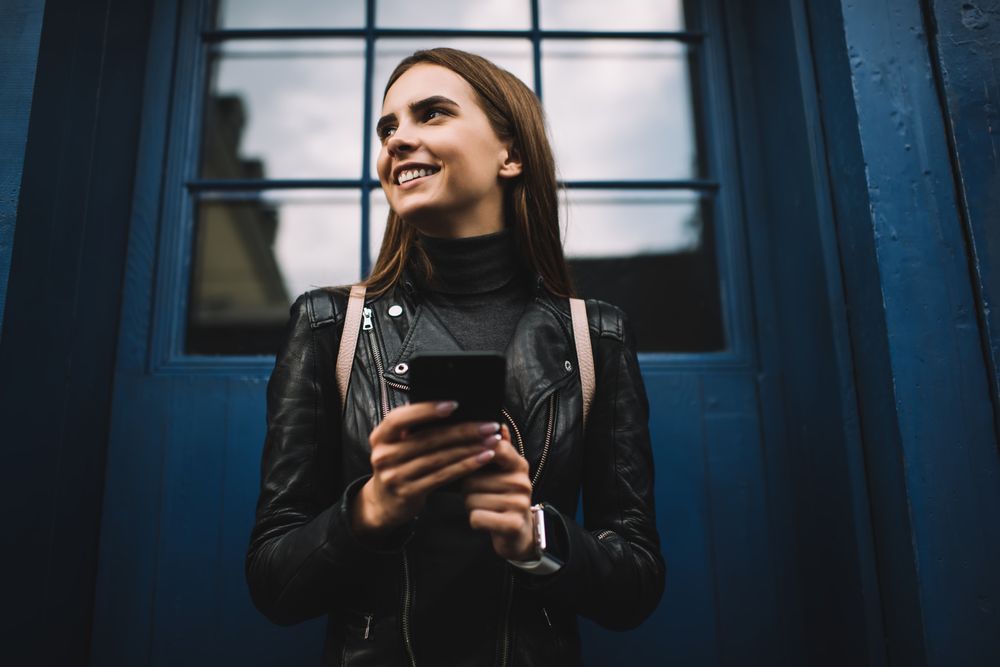 Woman holding a phone in her solo female travel