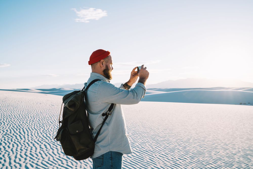 Hombre tomando una foto representando La Guía Definitiva del Equipo de Viaje en Solitario