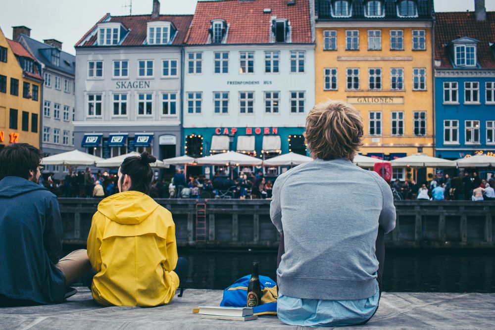 a man sitting by a canal solo traveling in Copenhagen, one of the best solo travel destinations