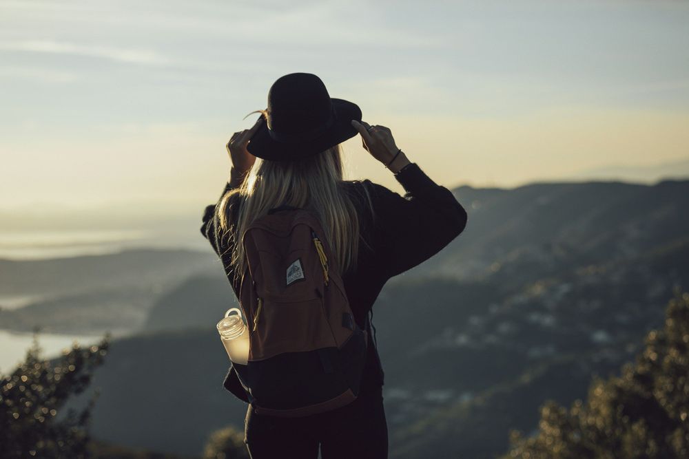 Woman overlooking a landscape, representing the decision between solo travel or group travel
