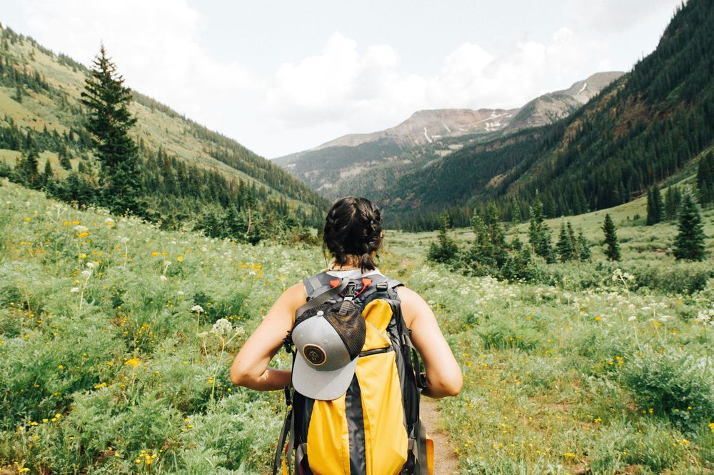 Woman traveling with a small backpack representing Budget Travel Tips
