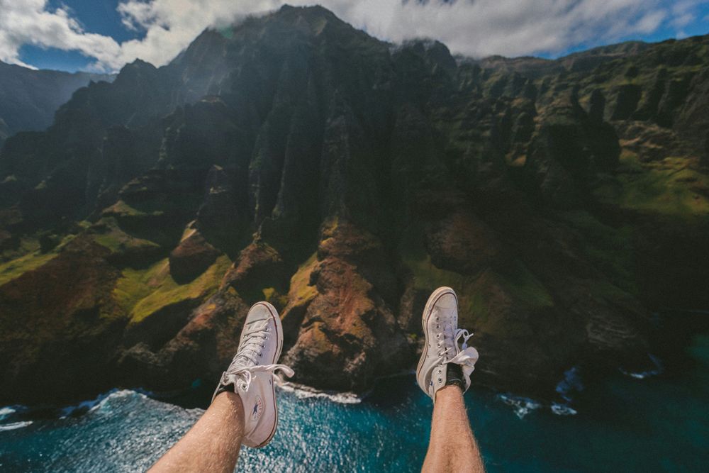 Legs of a man in a mountain background, representing 10 Travel Essentials You Need On Every Trip