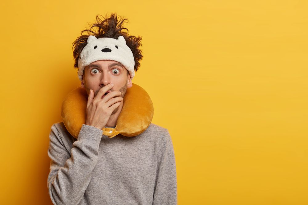 Man equipped with travel accessories as a representation on how to avoid jet lag