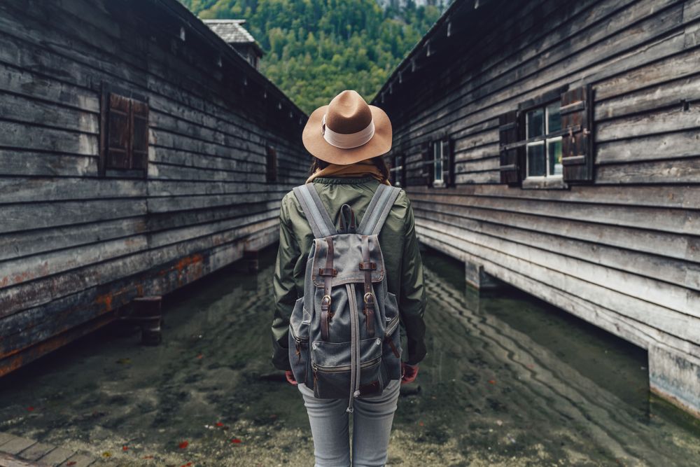 Woman’s back in a forest between cabins, staying vigilant is part of our Travel Tips and Tricks