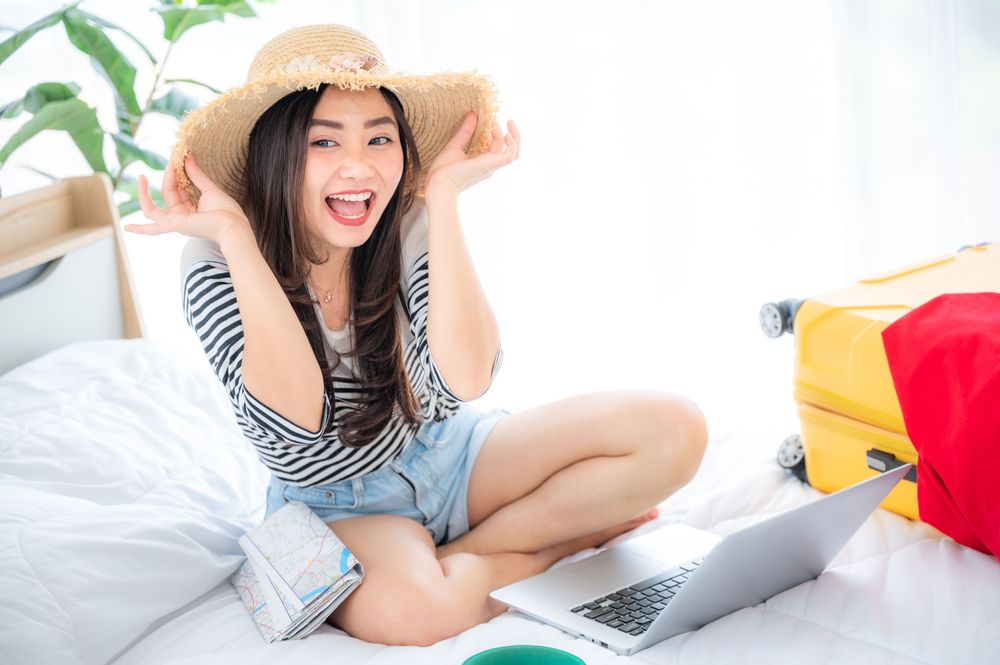 Woman working on a computer, establishing her budget and representing how to create a travel budget