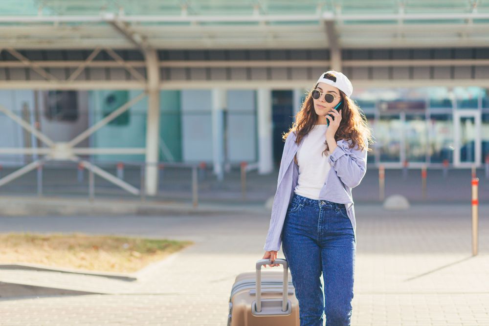 Young woman traveling alone getting in contact with someone, staying safe while traveling solo