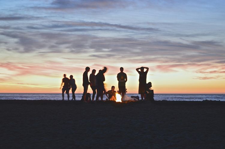 Group of friend in a beach, representing travel hacks to save money